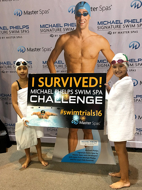 Twee meisjes laten trots zien dat ze de Michael Phelps Swim Spa Challenge hebben overleefd
