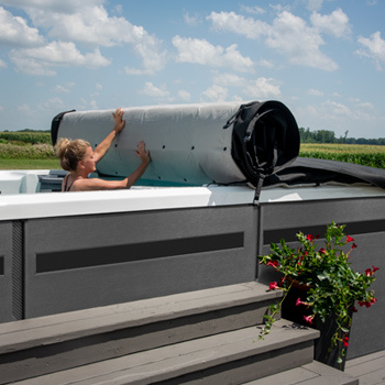 Vrouw die de Axis Cover vanuit een zwemspa terugrolt.